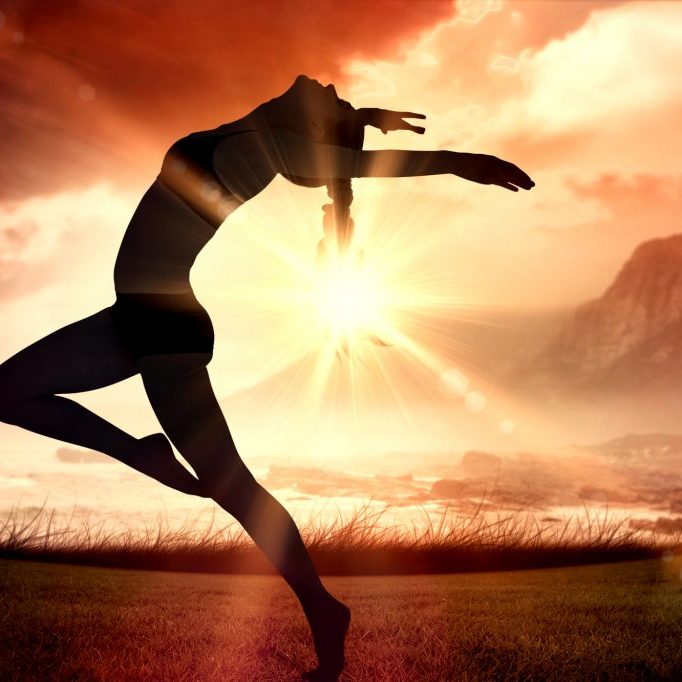Side view of a sporty young woman stretching against sunrise over magical sea